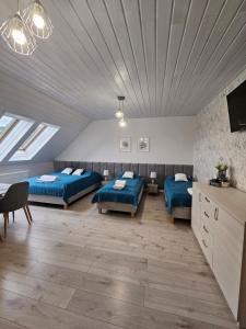 a large room with two beds and a tv at Pokoje Gościnne Pod Lipami in Kudowa-Zdrój