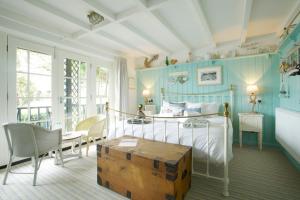 ein Schlafzimmer mit einem Bett, einem Tisch und Stühlen in der Unterkunft The Ness in Teignmouth