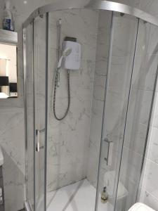 a shower with a glass door in a bathroom at Guest House Bungalow in Walsall