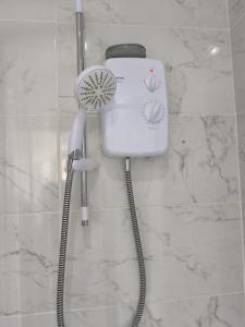 a blow dryer on a wall in a bathroom at Guest House Bungalow in Walsall