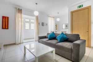 ein Wohnzimmer mit einem Sofa und einem Tisch in der Unterkunft Superb 3BR apt close to seafront in Gżira