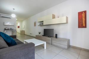 a living room with a couch and a tv at Superb 3BR apt close to seafront in Il-Gżira
