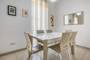 una sala da pranzo con tavolo e sedie bianchi di Superb 3BR apt close to seafront a Il-Gżira