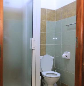 a bathroom with a toilet and a glass door at ACK Guest House Nairobi in Nairobi