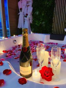 une bouteille de vin posée sur une table avec des bougies et des roses dans l'établissement Gîte de l'As de trèfle, à Feignies