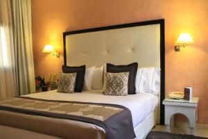 1 dormitorio con 1 cama grande y cabecero grande en Berbère Palace en Ouarzazate