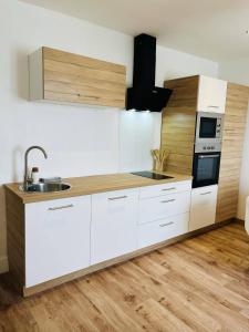 a kitchen with white cabinets and a sink at Gîte de l'As de Trèfle in Feignies