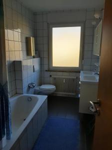 a bathroom with a tub and a toilet and a sink at Haus Roseneck-Pension Am Stadtrand in Borchen