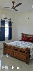 a first floor bedroom with a bed with blue curtains at Olive Hills Yelagiri - Families Only - Full Duplex House - Yelagiri in Yelagiri