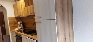 a white refrigerator in a kitchen with wooden cabinets at Fewo 2 Haus am Lärchenhang Leutasch in Leutasch +10 photos