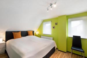 a bedroom with green and white walls and a bed at Ferienhaus Koch in Bad Harzburg