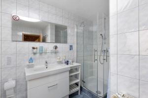 a white bathroom with a sink and a shower at Ferienhaus Koch in Bad Harzburg +17 photos