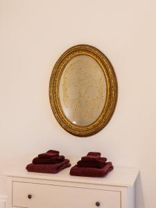 a mirror on a wall above a dresser with towels at Casa Misette 200mq a due passi dal mare in Alassio
