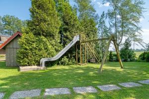 a playground with a slide in a yard at Haus Schöneck in Otterndorf