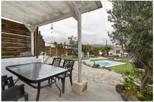 un patio con tavolo, sedie e piscina di 7 Moons Resort B Only Adults a San Bartolomé