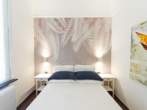 a bedroom with a white bed with two tables at Casa Misette 200mq a due passi dal mare in Alassio