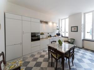 a kitchen with white cabinets and a table with chairs at Casa Misette 200mq a due passi dal mare in Alassio