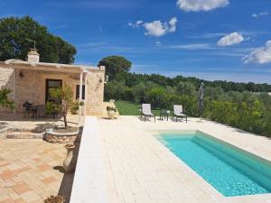 a swimming pool in front of a house with a patio at Fogliantica Azienda Agrituristica in Ceglie Messapica