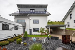 une maison avec un panneau solaire sur le toit et une caravane dans l'établissement Ferienwohnung Am Weissgerber, à Münsingen