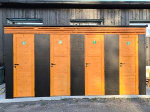 a row of wooden doors in front of a building at Kanarbiku camp in Türi
