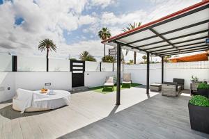 a white patio with a table on a roof at Sunset House Maspalomas in Playa del Ingles