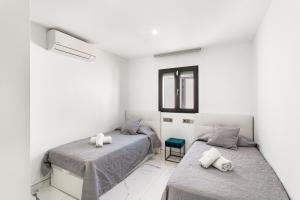 a bedroom with two beds and a window at Sunset House Maspalomas in Playa del Ingles +18 photos