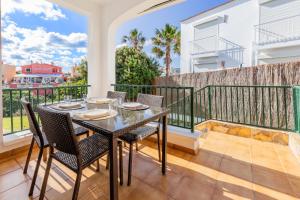 a dining room with a table and chairs on a balcony at Biniforcat in Cala en Forcat