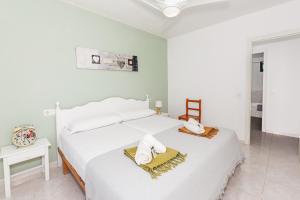 a white bedroom with a bed with towels on it at Biniforcat in Cala en Forcat +16 photos