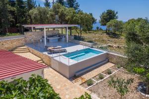 an outdoor swimming pool with a gazebo at Antipaxos sunset house in Antipaxos
