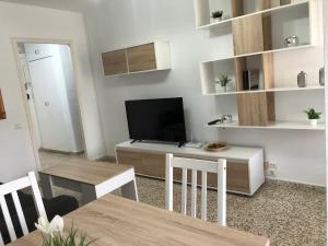 a living room with a dining table and a television at Apartamento vistas a piscina in Benalmádena