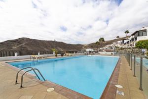 a swimming pool at a resort with mountains in the background at Bungalow Josephin in Patalavaca
