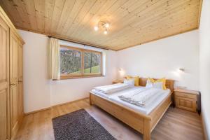 um quarto com uma cama e uma janela em Matscherhof Ferienwohnung Nikolaus em Motini al Rio