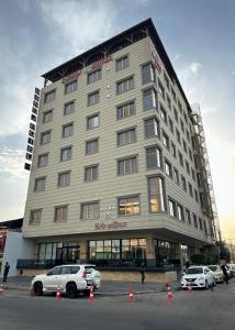 a large building with cars parked in front of it at Banoj Hotel in Erbil