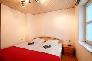 a bedroom with a red and white bed with two hats on it at Stumpp´s Appartement in Heroldstatt