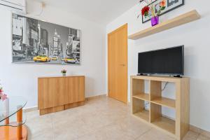 a living room with a flat screen tv on a stand at A 100m de la Playa Salou in Salou