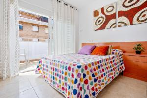 um quarto com uma cama e uma grande janela em A 100m de la Playa Salou em Salou