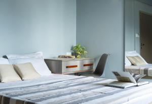 Un dormitorio con una cama con un escritorio y una silla. en YMCA International Guest House, en Trichūr