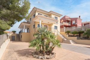 duży dom z palmami przed nim w obiekcie Luxury villa with swimmingpool w mieście Alginet