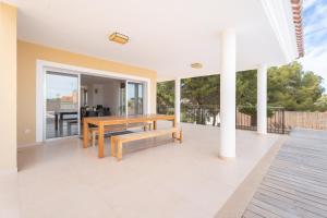 Luxury villa with swimmingpool في Alginet: فناء مع مقعد خشبي وطاولة