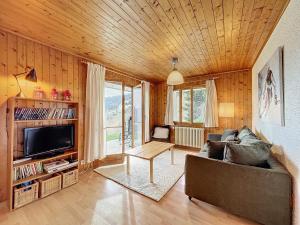 ein Wohnzimmer mit einem Sofa und einem TV in der Unterkunft Fouquet Apartments in Verbier