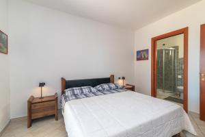 Habitación blanca con cama y espejo en I Mirti, en Porto Pozzo