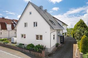 une maison blanche avec un toit noir dans l'établissement Ferienwohnung Faisst, à Kappel-Grafenhausen