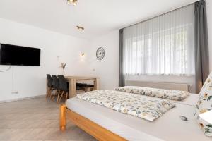 1 dormitorio con 2 camas y mesa con sillas en Ferienwohnung Faisst, en Kappel-Grafenhausen