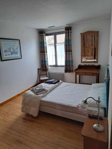 a bedroom with a bed and a desk and a window at Maison avec piscine in Marciac