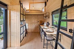 eine Küche in einem winzigen Haus mit einem Tisch und Stühlen in der Unterkunft Almhütte mit Tiny House in Ulrichstein
