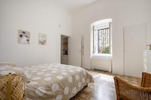 a white bedroom with a bed and a window at Maison Valentina in Monopoli