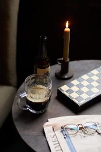 una mesa con una botella de vino y una vela y vasos en The Penny Bun, en Otley
