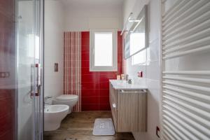 baño con aseo blanco y pared roja en Gufo di Mare - Rosso, en Savelletri di Fasano 12 fotos más