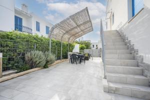 un patio con escaleras, mesa y sillas en Gufo di Mare - Rosso, en Savelletri di Fasano