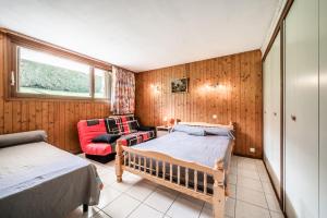 Un dormitorio con 2 camas y una silla. en Appartement en residence en Morzine